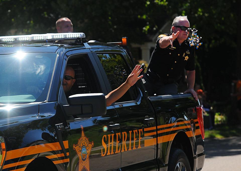 A Stark County Sheriff's deputy tosses candy to children in August 2022 during the 25th Dr. Martin Luther King Jr. Parade in Alliance. This year's parade will be Saturday, Aug. 26, 2023.