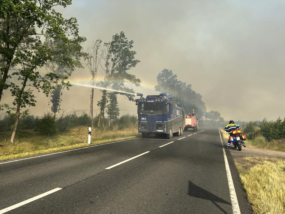 A police water cannon is in action in a forest fire in Treuenbrietzen, Germany, Sunday, June 19, 2022. The area affected by the forest fire in Treuenbrietzen near Berlin has expanded in the night to Sunday. (Thomas Schulz/dpa via AP)