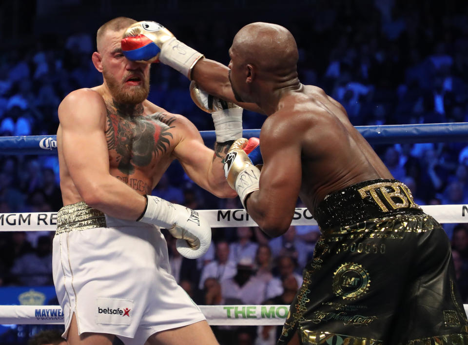 <p>(L-R) Floyd Mayweather Jr. throws a punch at Conor McGregor during their super welterweight boxing match on August 26, 2017 at T-Mobile Arena in Las Vegas, Nevada. </p>