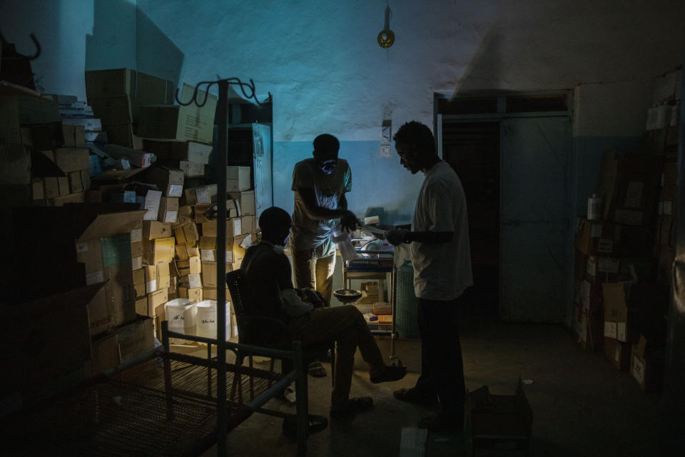 Surgeon and doctor-turned-refugee, Dr. Tewodros Tefera, checks a Tigrayan refugee inside the Sudanese Red Crescent clinic, at Hamdayet Transition Center near the Sudan-Ethiopia border, eastern Sudan, on March 23, 2021. Tewodros fills a growing number of notebooks as he compiles a “dossier” on the Tigray conflict. Sometimes he dreams of taking it to the International Criminal Court in a quest for justice. (AP Photo/Nariman El-Mofty)