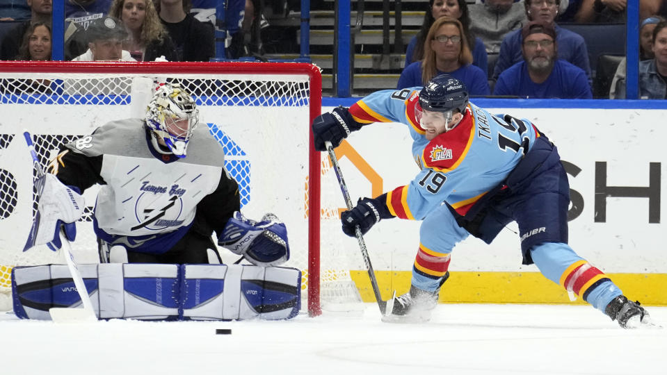 Florida Panthers left wing Matthew Tkachuk (19) makes a pass in front of Tampa Bay Lightning goaltender Andrei Vasilevskiy (88) during the second period of an NHL hockey game Saturday, Dec. 10, 2022, in Tampa, Fla. (AP Photo/Chris O'Meara)