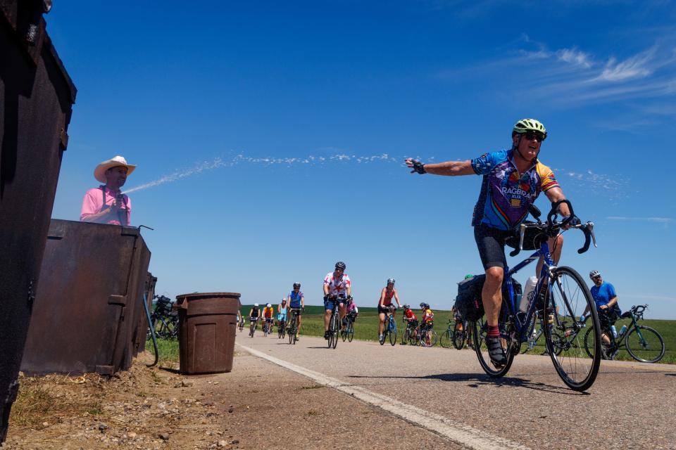 Mr. Pork Chop sprays a passing cyclist on RAGBRAI as they make their way from Sergeant Bluff to the day 1 meeting town of Anthon before ending the day in Ida Grove on Sunday, July 24, 2022