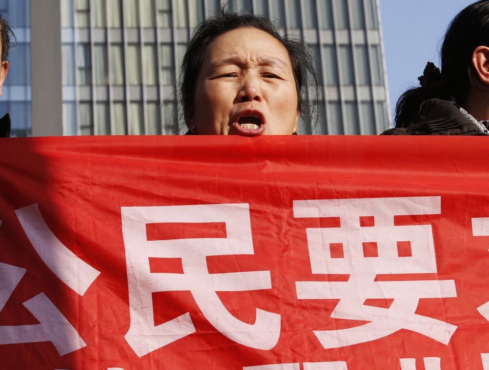 Supporters of Xu Zhiyong shout slogans near a court where Xu's trial is being held, in Beijing