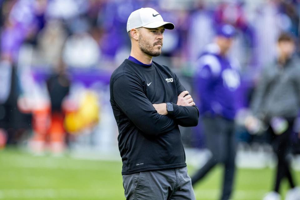 Garrett Riley crosses his arms and watches TCU players as they warm up