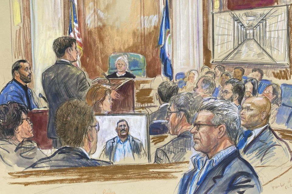 This artist sketch depicts Salah Al-Ejaili, foreground with glasses, a former Al-Jazeera journalist, before the U.S. District Court in Alexandria, Va., Tuesday, April 16, 2024. Al-Ejaili, a former detainee at the infamous Abu Ghraib prison, has described to jurors the type of abuse that is reminiscent of the scandal that erupted there 20 years ago: beatings, being stripped naked and threatened with dogs, stress positions meant to induce exhaustion and pain. (Dana Verkouteren via AP)