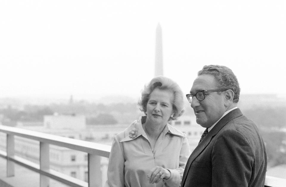 FILE - Margaret Thatcher, left, leader of Great Britain's Conservative Party, looks at the Capitol from a balcony of the State Department in Washington, Sept. 18, 1975, with Secretary of State Henry Kissinger. In background is the Washington Monument. Kissinger, the diplomat with the thick glasses and gravelly voice who dominated foreign policy as the United States extricated itself from Vietnam and broke down barriers with China, died Wednesday, Nov. 29, 2023. He was 100. (AP Photo/Bob Daugherty, File)