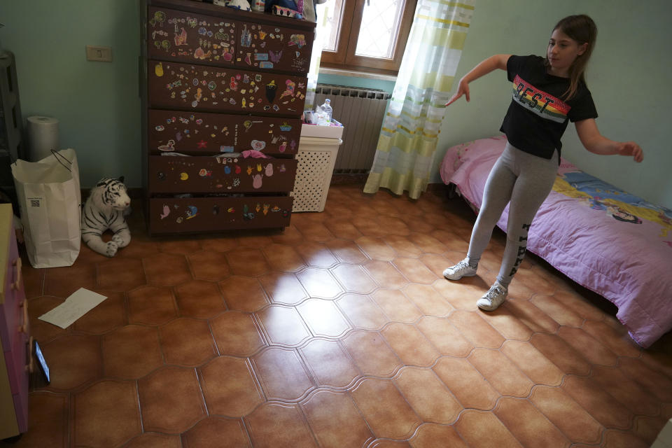 Elena Moretti looks at her cellphone as she attends an online dancing lesson, in her bedroom in Rome, Thursday, May 14, 2020 during the COVID-19 coronavirus lockdown. Sometimes the internet connection goes out. But she’s still managed to keep in touch with friends, with some video chats lasting for hours. (AP Photo/Andrew Medichini)