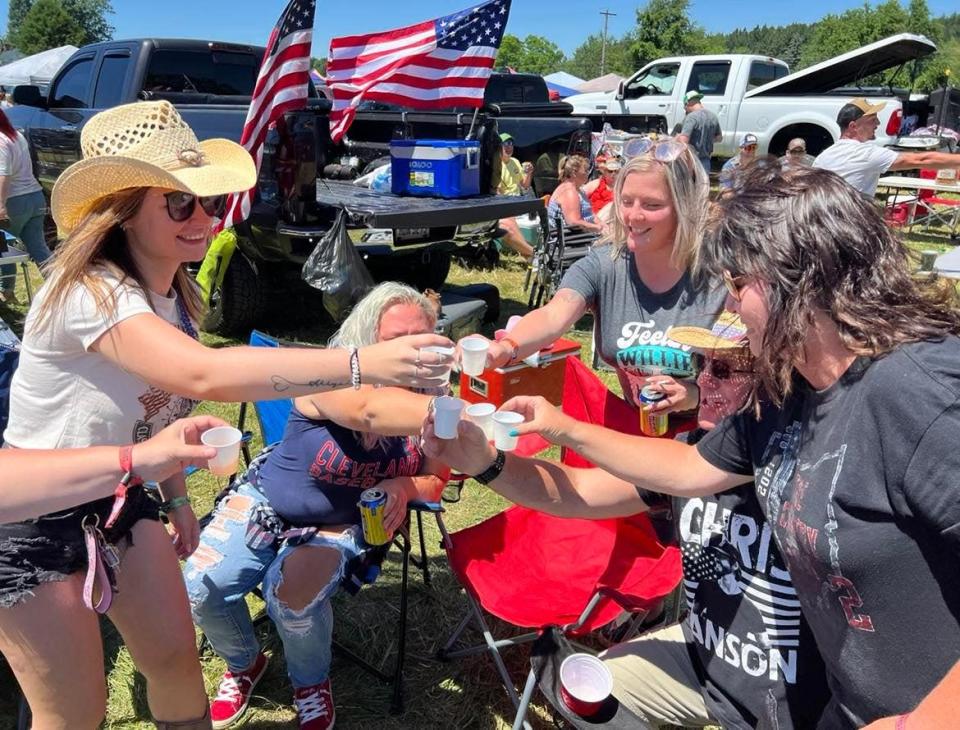 A group of Country Fest fans get ready to take a shot of alcohol on Saturday on the final day of the music event.