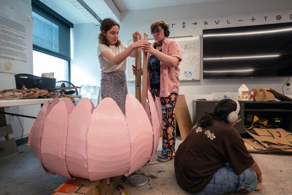 Grace Ozzello of Council Bluffs, Iowa, and Daniel Ifarig of Kansas City work on their pink lotus vehicle before the annual Rail Day event.