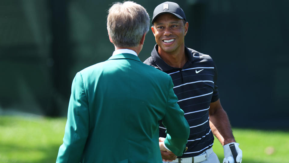 Tiger Woods greets an official at the Masters in Augusta.