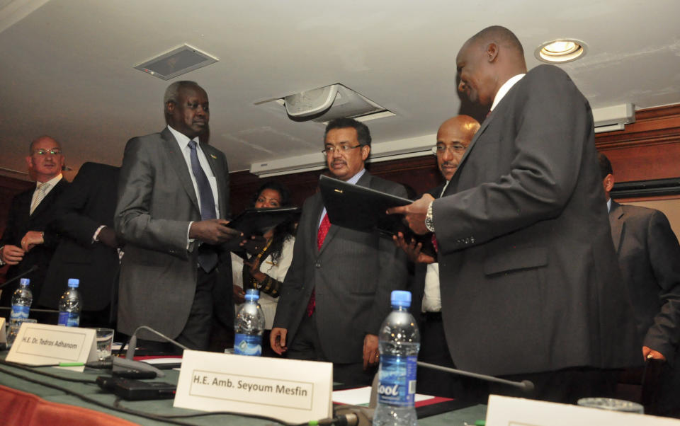 Nhail Deng Nhail, 2nd left, the head of South Sudan's negotiating team, and top negotiator for the rebel's side, Taban Deng Gai, right, a general in South Sudan's army before he defected, sign a cessation of hostilities agreement in front of mediator Ethiopian Foreign Minister Tedros Adhanom, center, in Addis Ababa, Ethiopia Thursday, Jan. 23, 2014. South Sudan's government and rebels fighting against it have signed Thursday a cessation of hostilities agreement in Addis Ababa that should at the least put a pause to five weeks of warfare that has claimed thousands of lives and uprooted a half million people since fighting began Dec. 15 between the government and supporters of former Vice President Riek Machar. (AP Photo/Elias Asmare)