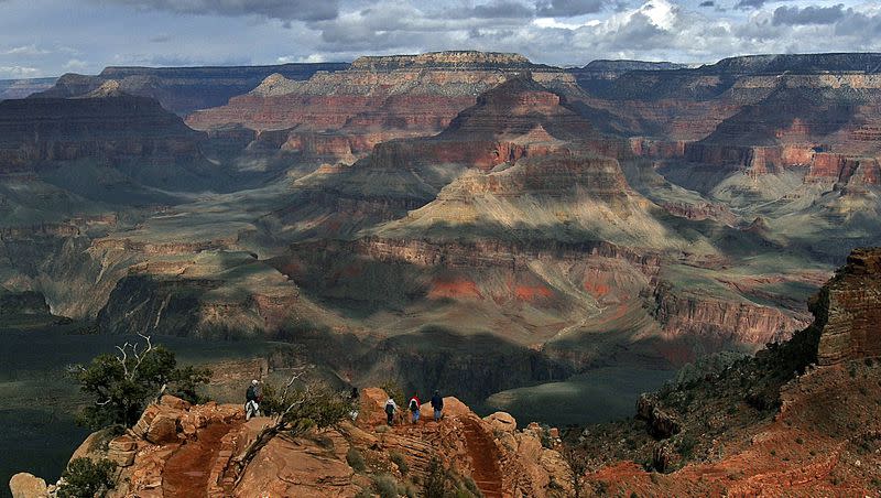 Tourists hike along the South Rim of the Grand Canyon in Grand Canyon, Ariz. on Feb. 22, 2005. Park officials say a woman died from heat-related illness Monday, July 3, 2023 while hiking in the Tuweep area of Grand Canyon National Park.