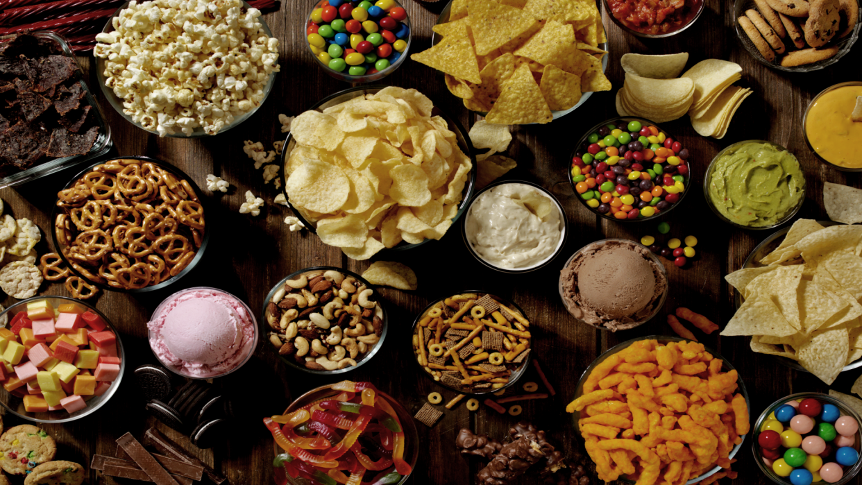 Table filled with pretzels, candy, and other snack foods