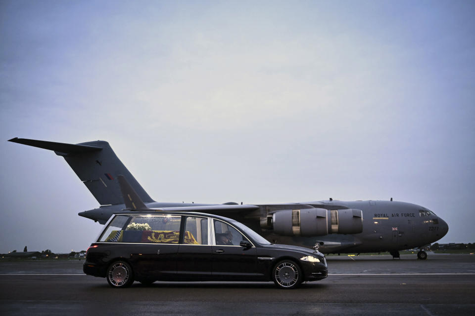 The coffin of Queen Elizabeth II is taken away in the Royal Hearse from the Royal Air Force Northolt airbase, London, Tuesday, Sept. 13, 2022. The queen's coffin is flown back to RAF Northolt, an air force base in London, and driven to Buckingham Palace. (Ben Stansall, Pool Photo via AP)