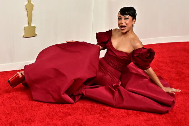 <p>FREDERIC J. BROWN/AFP via Getty </p> Liza Koshy falling on the 2024 Oscars red carpet