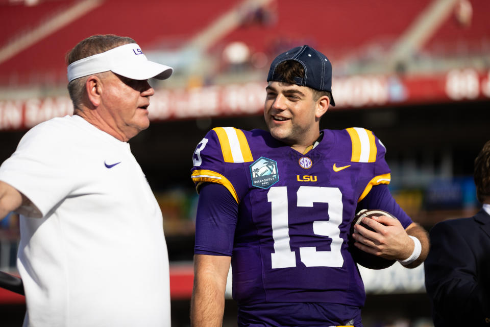 Jan 1, 2024; Tampa, FL, USA; LSU Tigers head coach Brian Kelly and quarterback Garrett Nussmeier (13) talk on the podium after the game against the Wisconsin Badgers at the Reliaquest Bowl at Raymond James Stadium. Mandatory Credit: Matt Pendleton-USA TODAY Sports