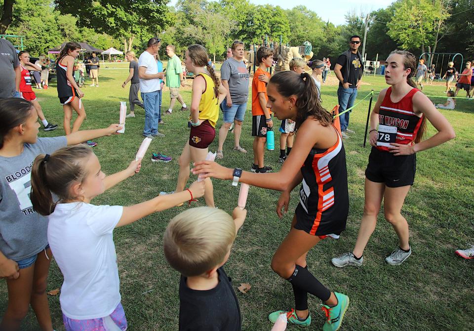 Runners grab a popsicle at the end of the race during the Fort Madison Invitational Thursday at Rodeo Park in Fort Madison.
