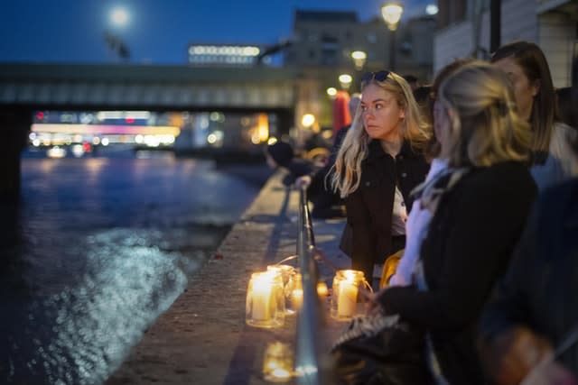 Mourners look out at the Thames after the the Bishop of Southwark held a short service