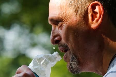 A man drinks water on a hot summer day in Central Park, Manhattan, New York, U.S., July 1, 2018. REUTERS/Eduardo Munoz