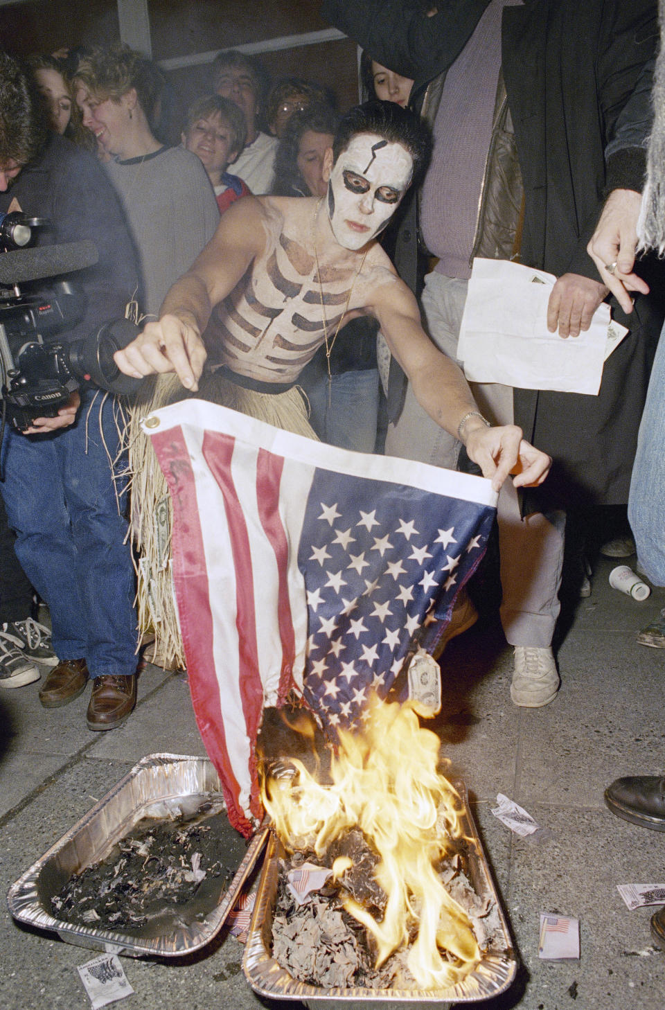 FILE - A Seattle resident, who refused to identify himself, burns an American flag in Seattle, Oct. 28, 1989, a few moments after a federal anti-flag burning law went into effect. Burning American flags dates back at least to the Civil War. But only in July 1968, in response to Vietnam War protesters, did Congress pass legislation making it illegal (the Supreme Court overturned the ban in 1989) and adding other restrictions against “publicly mutilating” the flag. (AP Photo/Jim Davidson, File)