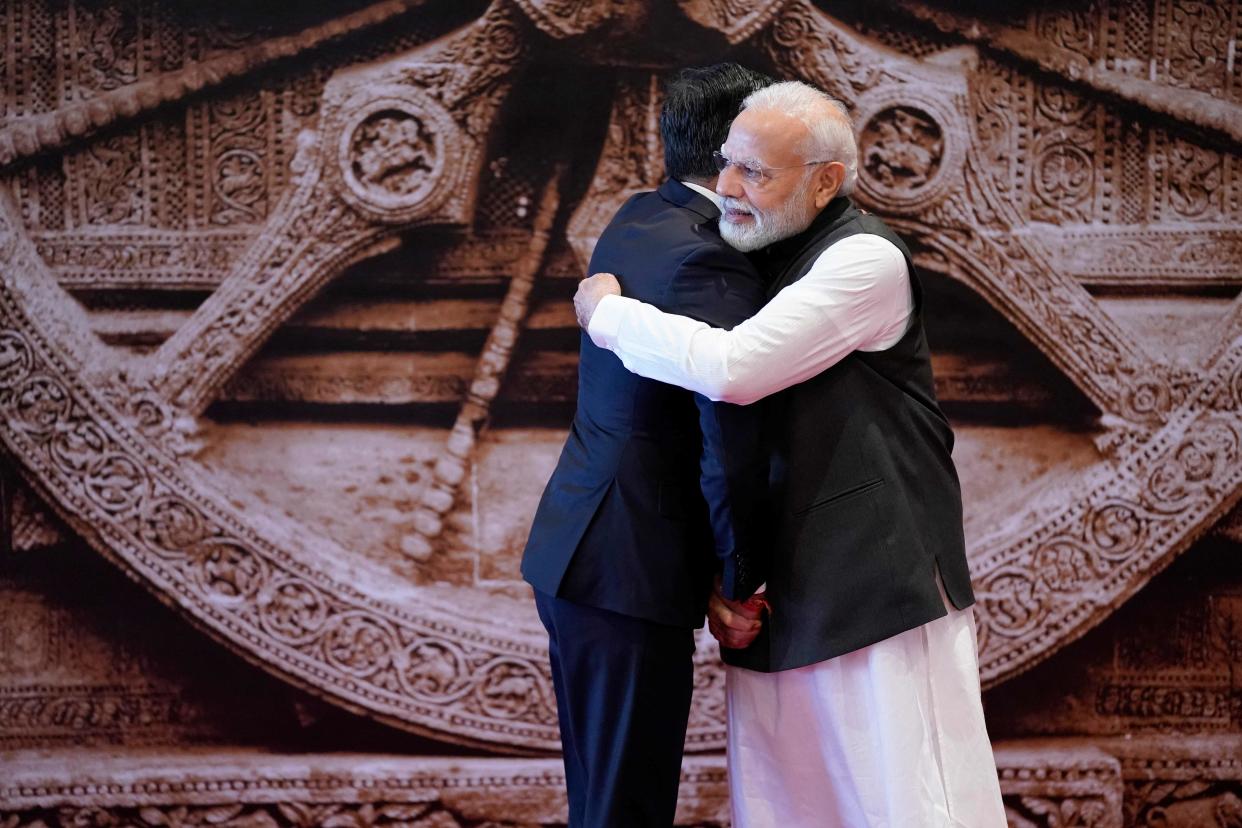 India's Prime Minister Narendra Modi (R) hugs as he greets Britain's Prime Minister Rishi Sunak (POOL/AFP via Getty Images)