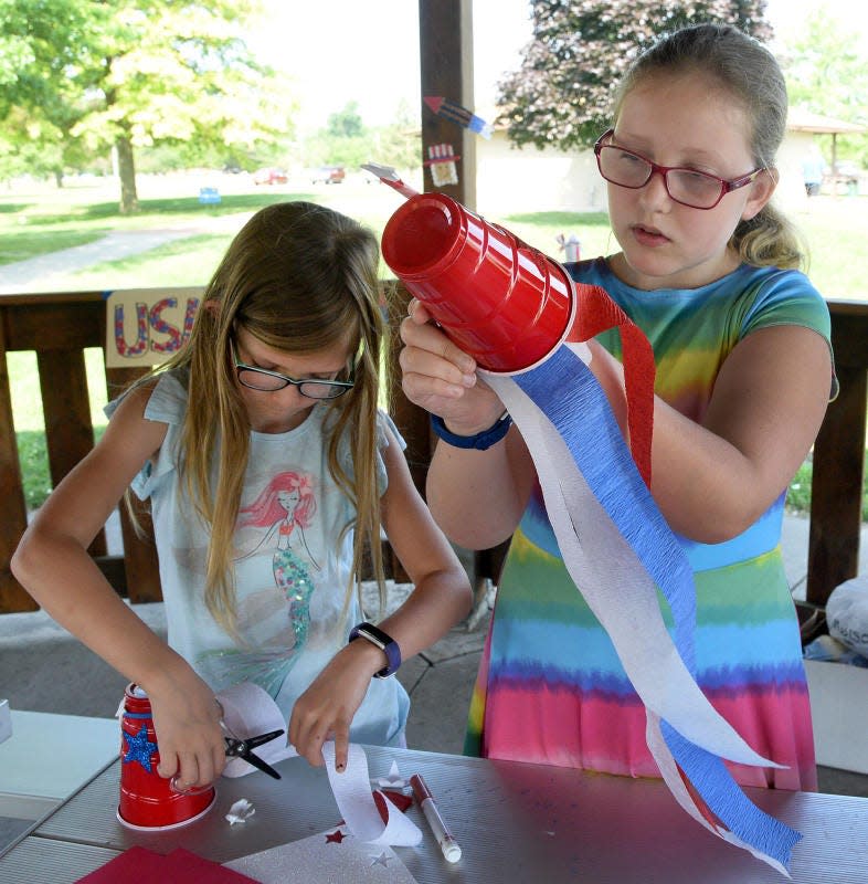 Evelyn Nash, (left) then 7, and her sister Magdalene, 10, construct red, white and blue wind socks at the Munson Park Tot Lot in 2019. Tot Lots in the City of Monroe resume June 20.
Monroe News file photo by Tom Hawley