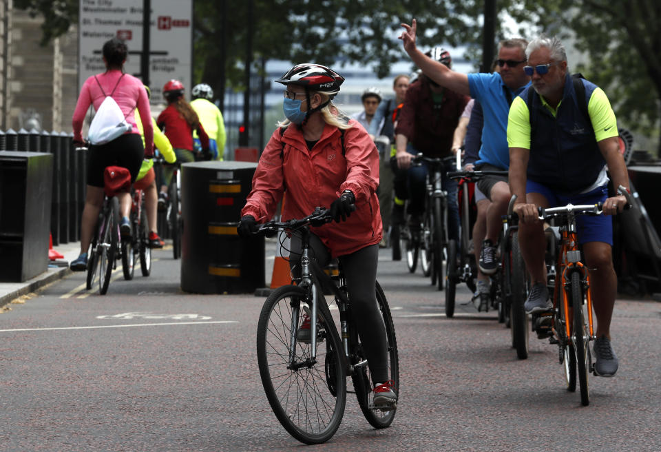 People cycle through Westminster area of London, Sunday, May 10, 2020 during the nation-wide coronavirus lockdown. Personal exercise while observing social distancing measures is allowed under government lockdown guidelines. (AP Photo/Frank Augstein)