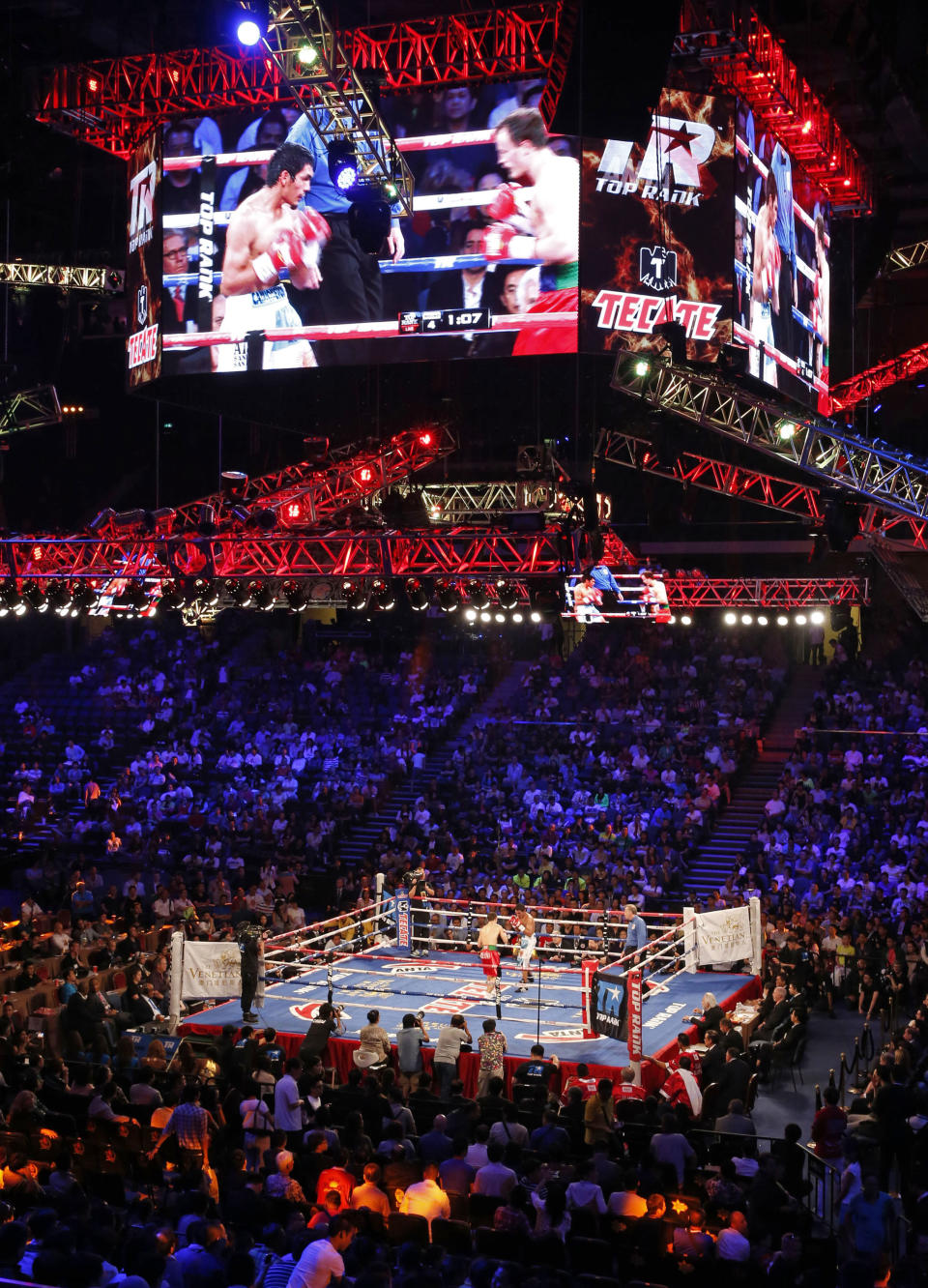 In this July 27, 2013 photo, Argentina's Mauricio Munoz, left, fights against Russia's Evgeny Gradovich in the ring during their IBF Featherweright title match at the Cotai Arena in Venetian Macao in Macau. A Chinese fighter’s victory at a Macau showdown brings the world’s top casino market a step closer to challenging Las Vegas for dominance of another Sin City staple: big-time boxing matches. Macau, which long ago eclipsed Vegas as the world's top gambling city, is now looking to add to its allure by holding the kind of boxing bouts that Las Vegas is known for. (AP Photo/Dennis Ho)