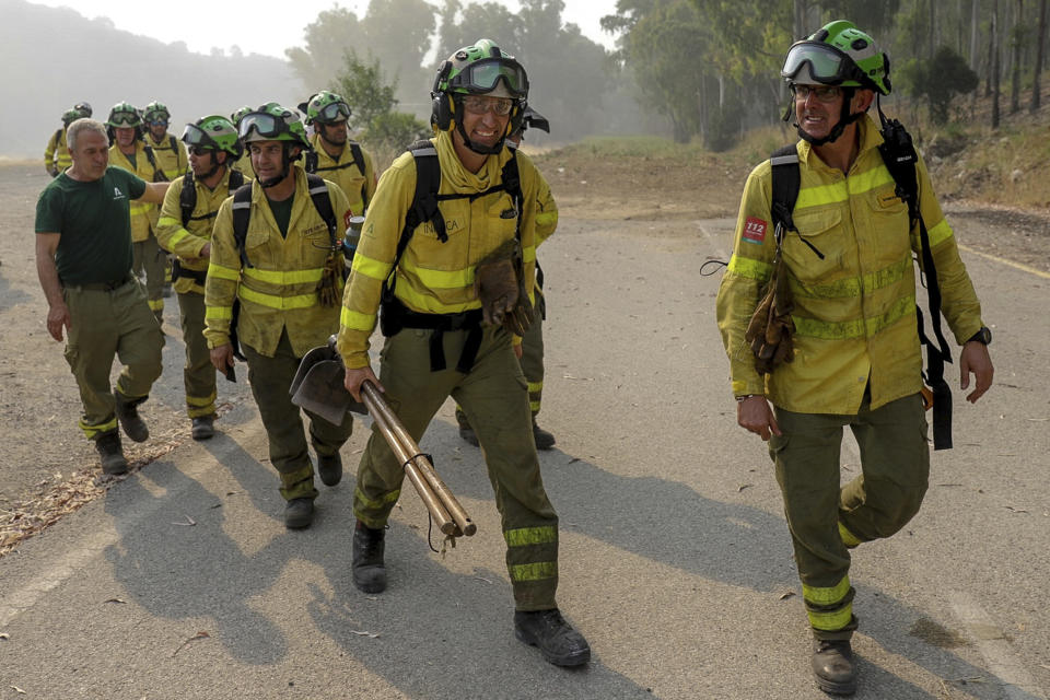 Firefigters walk in the area of a wildfire in Pujerra, Malaga, on Thursday, June 9, 2022. Emergency services deployed almost 1,000 firefighters, military personnel and support crews Thursday to fight a wildfire that has forced the evacuation of some 2,000 people in southern Spain amid fears that torrid weather may feed the blaze. (Alex Zea, Europa Press via AP)