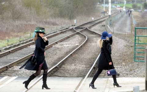 Racegoers cross the tracks - Credit: Paul Nicholls / Barcroft Images