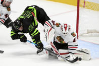 Chicago Blackhawks goaltender Kevin Lankinen (32) blocks a shot attempt by Dallas Stars defenseman Esa Lindell (23) in the first period during an NHL hockey game in Dallas, Thursday, March 11, 2021. Looking on is Blackhawks defenseman Calvin de Haan (44). (AP Photo/Matt Strasen)