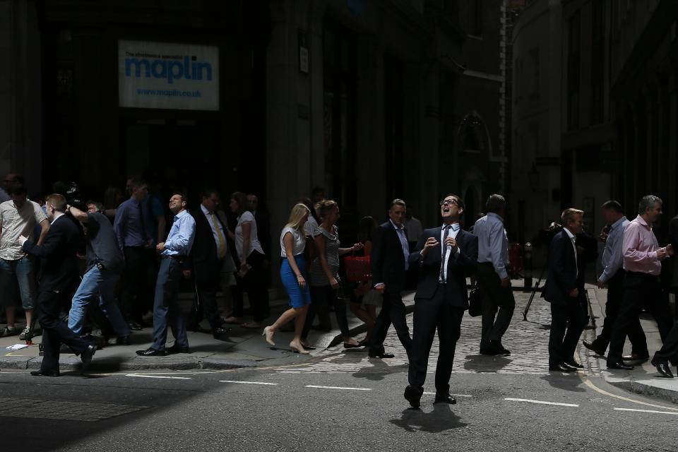 A member of the media reacts as reflected sunlight from the Walkie Talkie tower hits him, in central London