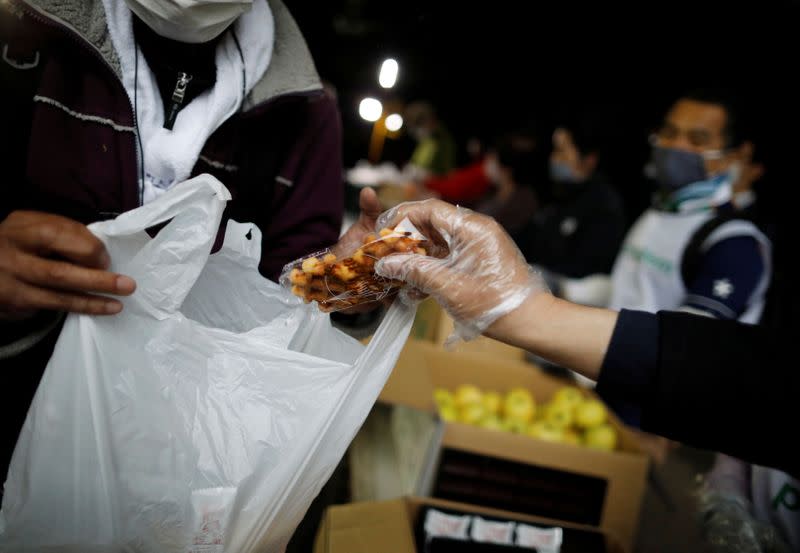 An elderly man receives food aid handouts, as the spread of the coronavirus disease (COVID-19) continues in Tokyo