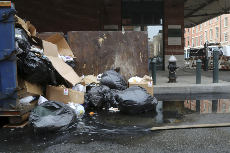 In this Thursday, Feb. 7, 2013 photo, water flows from a manhole next to garbage overflowing from a dumpster on the corner of Front St. and Beekman St. in New York. Nearly four months after Superstorm Sandy hit, the historic cobblestone streets near the water's edge in lower Manhattan are eerily deserted, and among local business owners, there is a pervasive sense that their plight has been ignored by the rest of Manhattan. (AP Photo/Mary Altaffer)