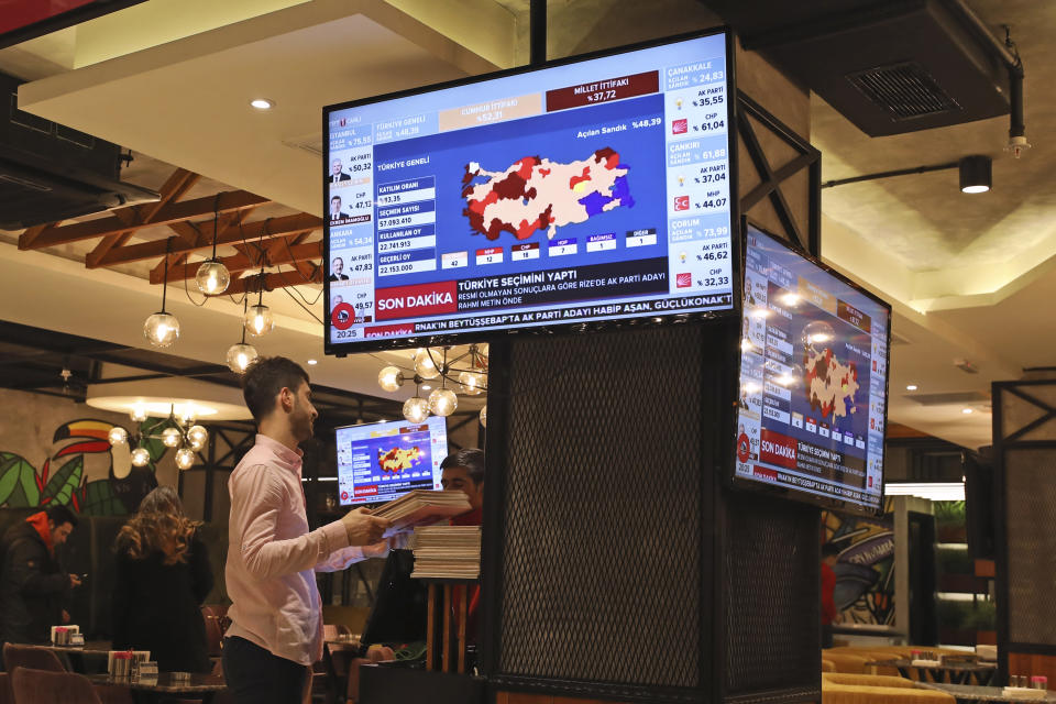 TV coverage of the local elections is seen on screens in a restaurant in Istanbul, Sunday, March 31, 2019. Mayoral elections are underway in 30 large cities in Turkey along with other municipal races Sunday that are seen as a barometer of President Recep Tayyip Erdogan's popularity amid a sharp economic downturn in the nation straddling Europe and Asia. (AP Photo/Emrah Gurel)