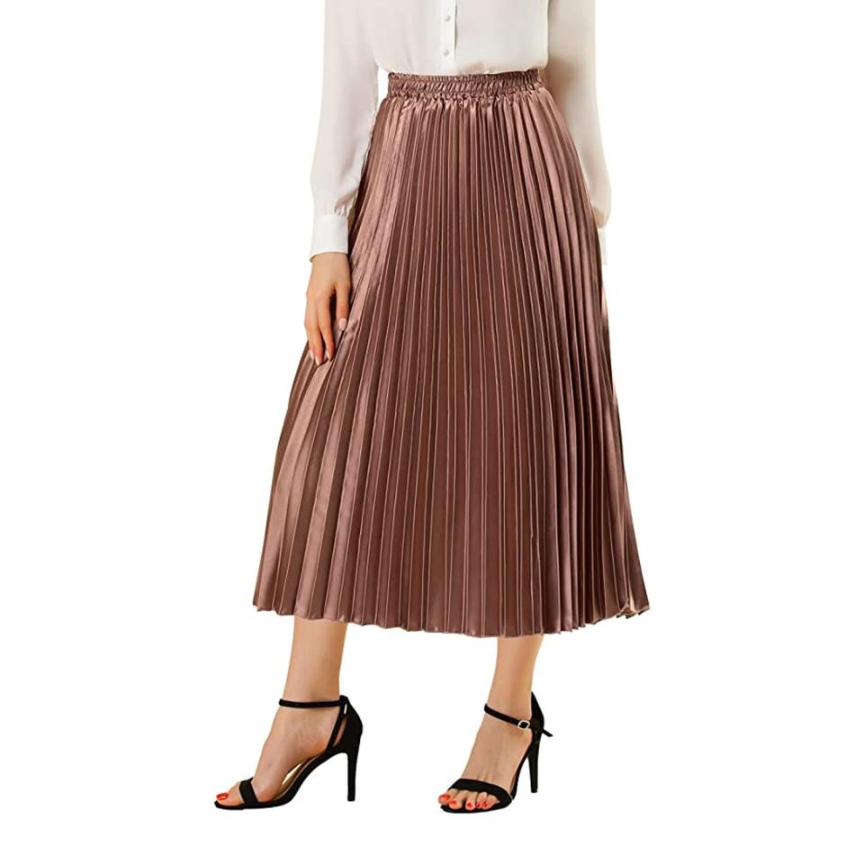 woman wearing pleated skirt, white top, and black strappy heels