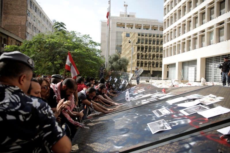 Protesters knock down the fencing as they demonstrate outside of Lebanon Central Bank during ongoing anti-government protests in Beirut