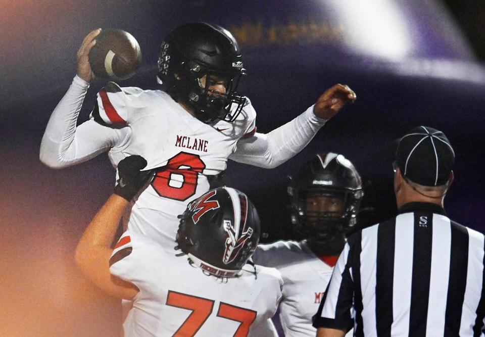 McLane quarterback Noah Zamora, top, is lifted high after running the ball in for a touchdown against Fresno Thursday, Sept. 14, 2023 in Fresno.