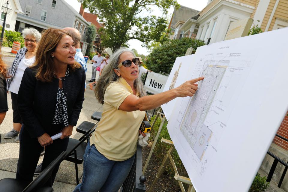 Barbara Conolly, co-designer of the Abolition Row Park, shows a floor plan of the proposed park to Lt Gov Karyn Polito during the press conference announcing a MOTT Destination Development Captial Grant awarded to the Abolition Row Park on Seventh Street in New Bedford.