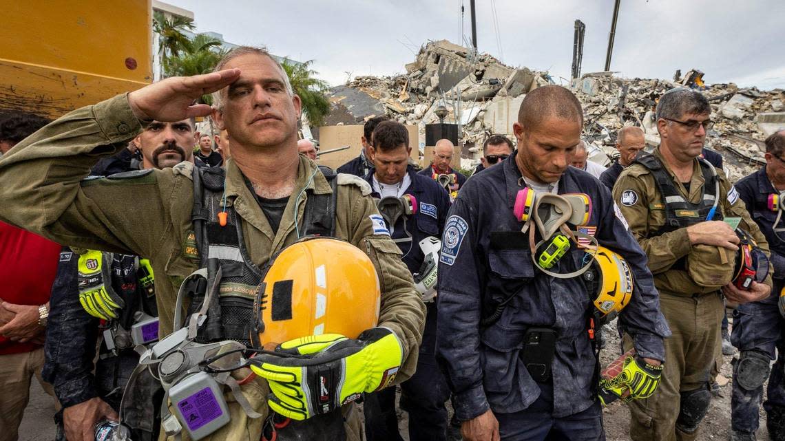 A member of the Israeli search-and-rescue team salutes during a prayer ceremony in front of the rubble left by the collapse of Champlain Towers South in Surfside.