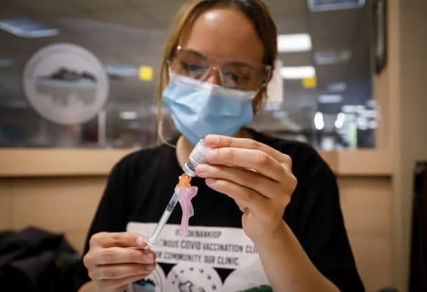 Nurse Iciar Bercian prepares a shot at a vaccine clinic for the homeless in Calgary on June 2. Scientists and doctors are warning that the more contagious delta variant could drive a fourth wave of cases, if not kept in check. (Jeff McIntosh/Canadian Press - image credit)