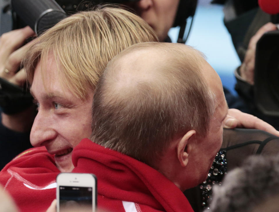 Russian President Vladimir Putin, right, embraces Evgeni Plushenko after Russia placed first in the team figure skating competition at the Iceberg Skating Palace during the 2014 Winter Olympics, Sunday, Feb. 9, 2014, in Sochi, Russia. (AP Photo/Ivan Sekretarev)