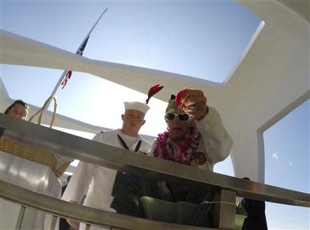 Pearl Harbor survivor Allen Bodenlos drops rose pedals into the "Rememberance Well" as US Navy CTR1 Michael Temple watches while aboard the USS Arizona Memorial during the 72nd anniversary of the attack on Pearl Harbor at the WW II Valor in the Pacific National Monument in Honolulu, Hawaii on December 7, 2013. REUTERS/Hugh Gentry