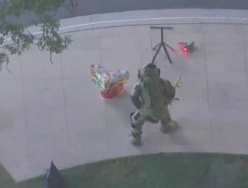 A Glendale Police Department bomb squad member approached a painted toilet left near the Americana Mall (screengrab/KTLA)