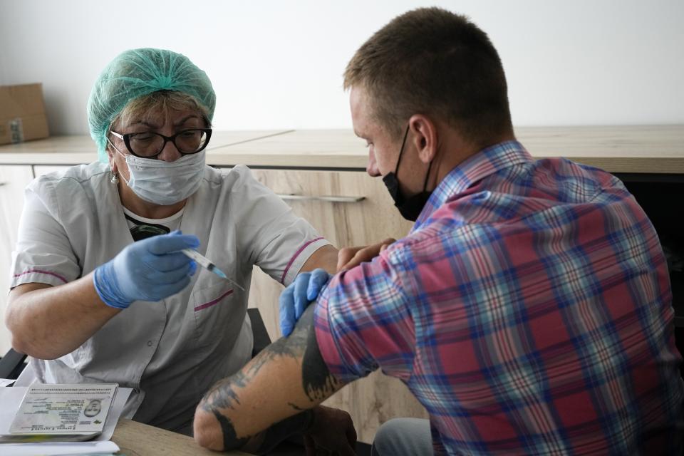 A medical worker prepares to give an injection of Russia's Sputnik V coronavirus vaccine to an employee of Oleg Sirota's cheese factory in Dubrovskoye village, in Istra district, 51 km. (31,8 miles) west of Moscow, Russia, Thursday, July 15, 2021. Thursday is the deadline the authorities set for eligible companies to ensure that 60% of their staff receive at least one shot of a vaccine. Sirota, founder of a cheese factory that has dozens of retail outlets in and around the Russian capital, said that as of Thursday, 70% of staff have received their shots, but the reluctance was difficult to overcome. (AP Photo/Alexander Zemlianichenko)