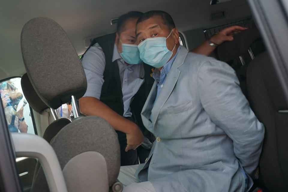 Hong Kong media tycoon Jimmy Lai, right, who founded local newspaper Apple Daily, is arrested by police officers at his home in Hong Kong, Monday, Aug. 10, 2020. Lai was arrested Monday on suspicion of collusion with foreign powers, his aide said, in the highest-profile use yet of the new national security law Beijing imposed on the city after protests last year. (AP Photo)