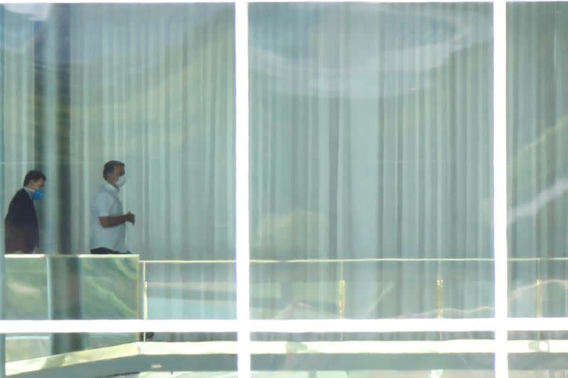 Brazil's President Jair Bolsonaro, wearing a protective mask, is seen at the Alvorada Palace, after reports of the coronavirus in Brasilia