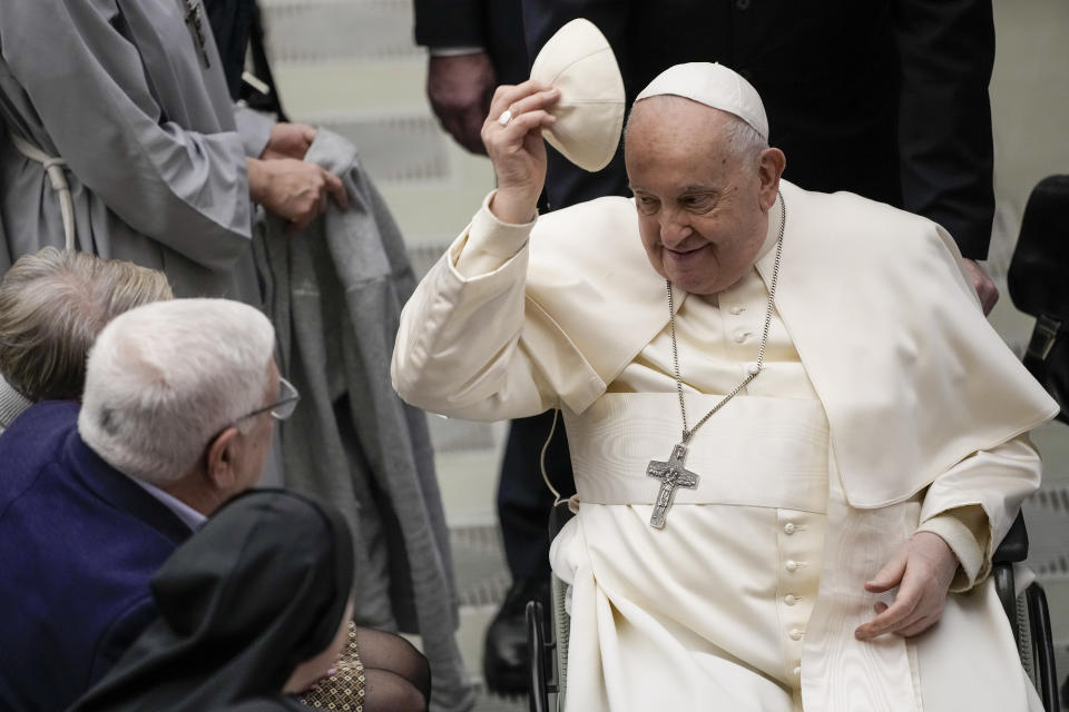 Pope Francis tries a skull cap he was offered during his weekly general audience in the Pope Paul VI hall at the Vatican, Wednesday, Jan. 31, 2024. (AP Photo/Andrew Medichini)