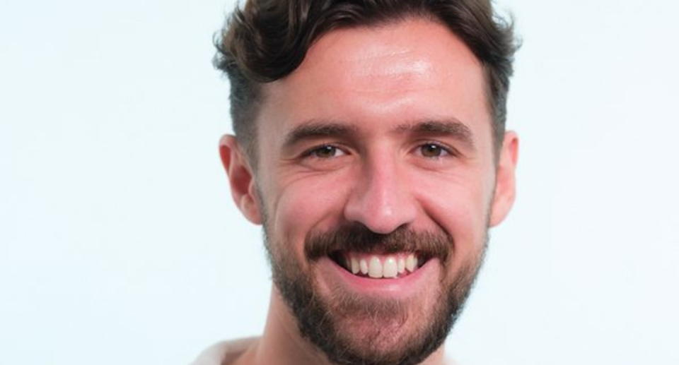 Portrait of smiling man on light-blue background.