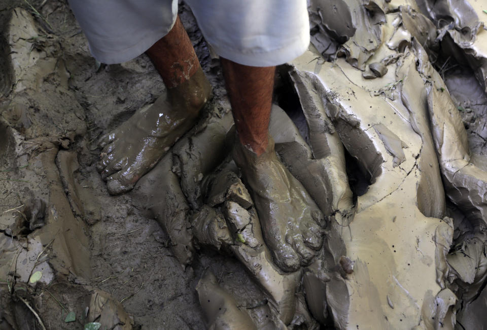 A man stand in mud after floodwaters hit his home, in Charsadda, Pakistan, Tuesday, Aug. 30, 2022. Disaster officials say nearly a half million people in Pakistan are crowded into camps after losing their homes in widespread flooding caused by unprecedented monsoon rains in recent weeks. (AP Photo/Mohammad Sajjad)